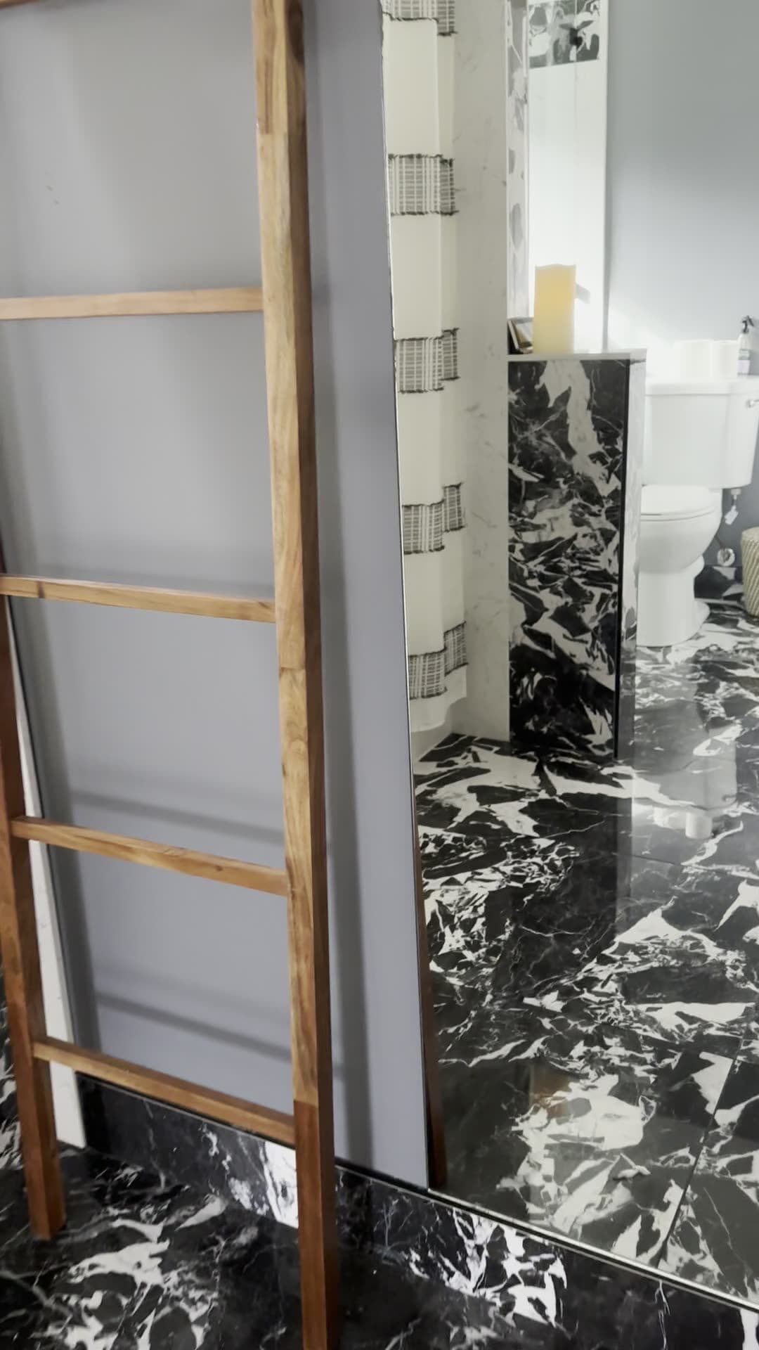 Black marble-look stone run full height up the wall instead of tile