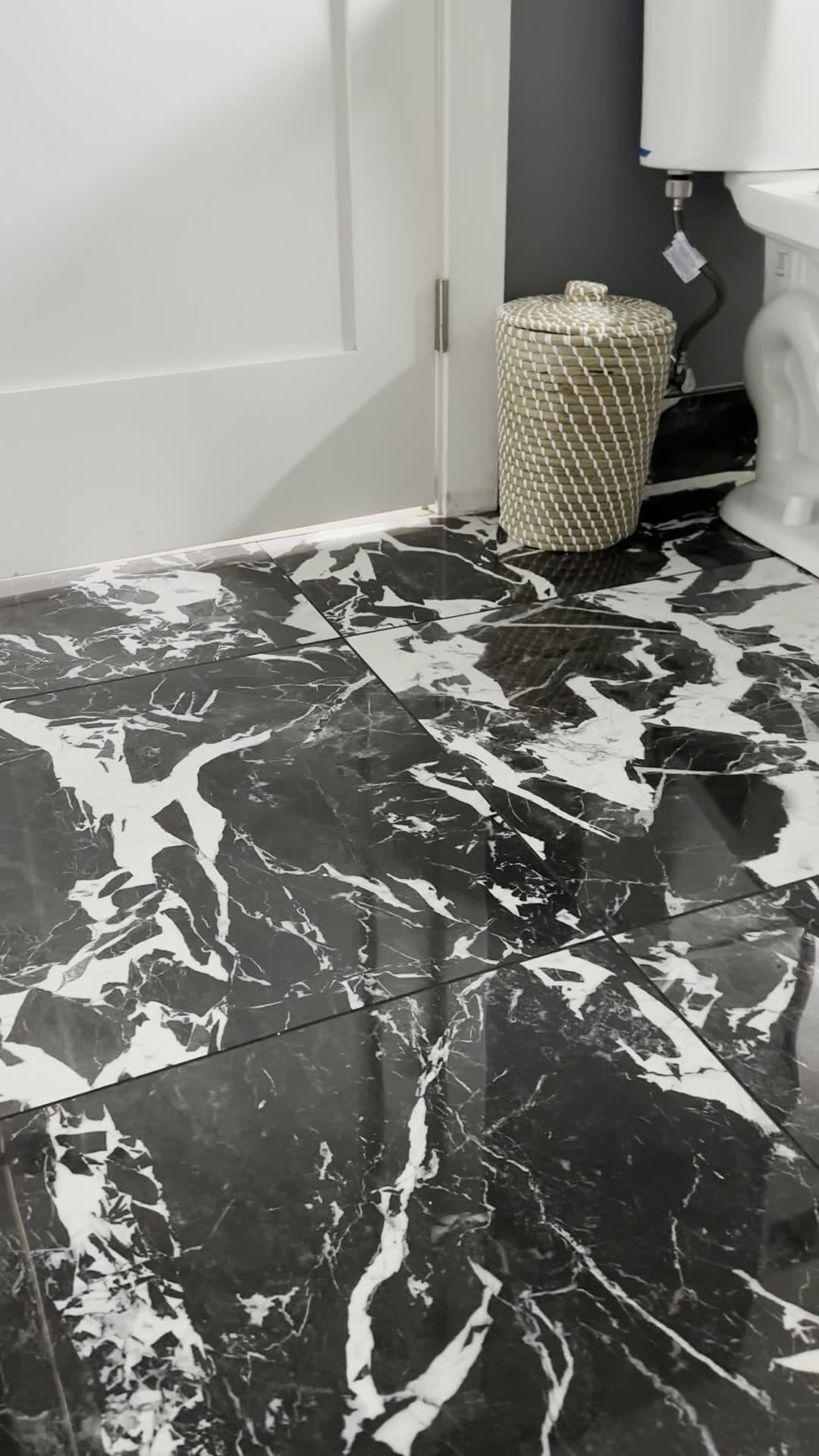 Polished black porcelain floor tile with bold white veining