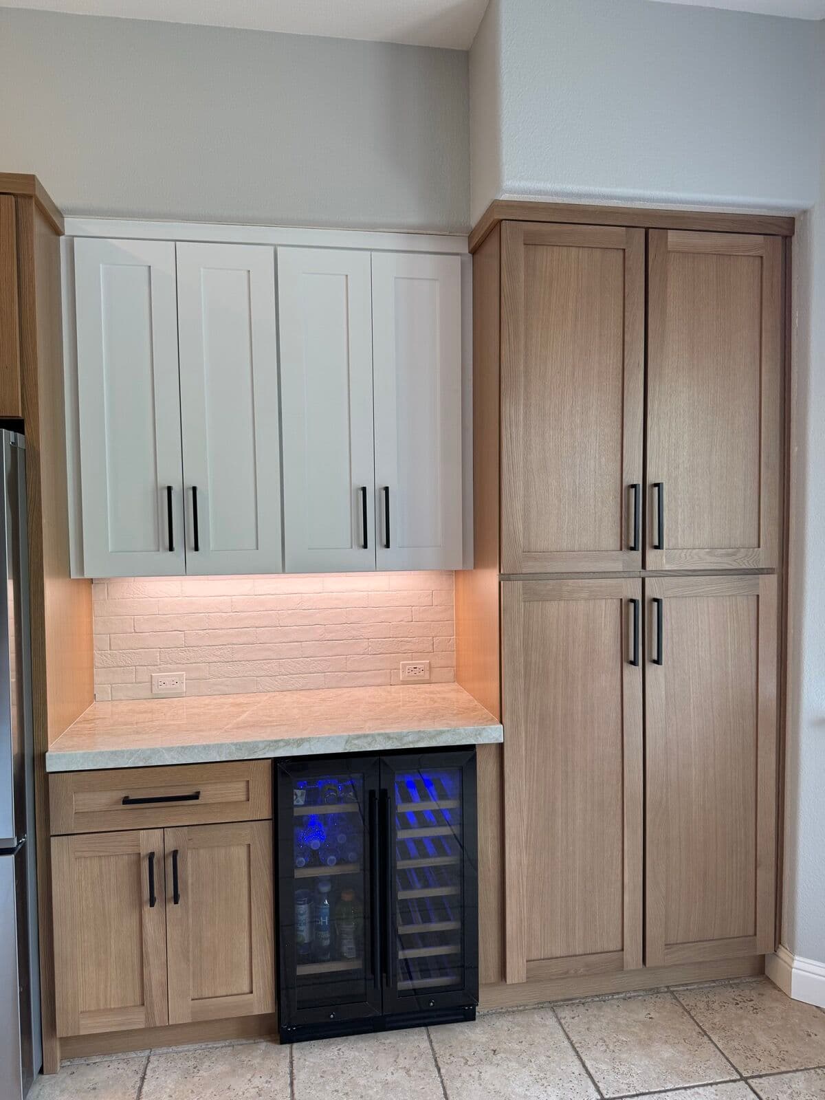 Bar area with white uppers, beverage cooler and rift white-oak pantry cabinets