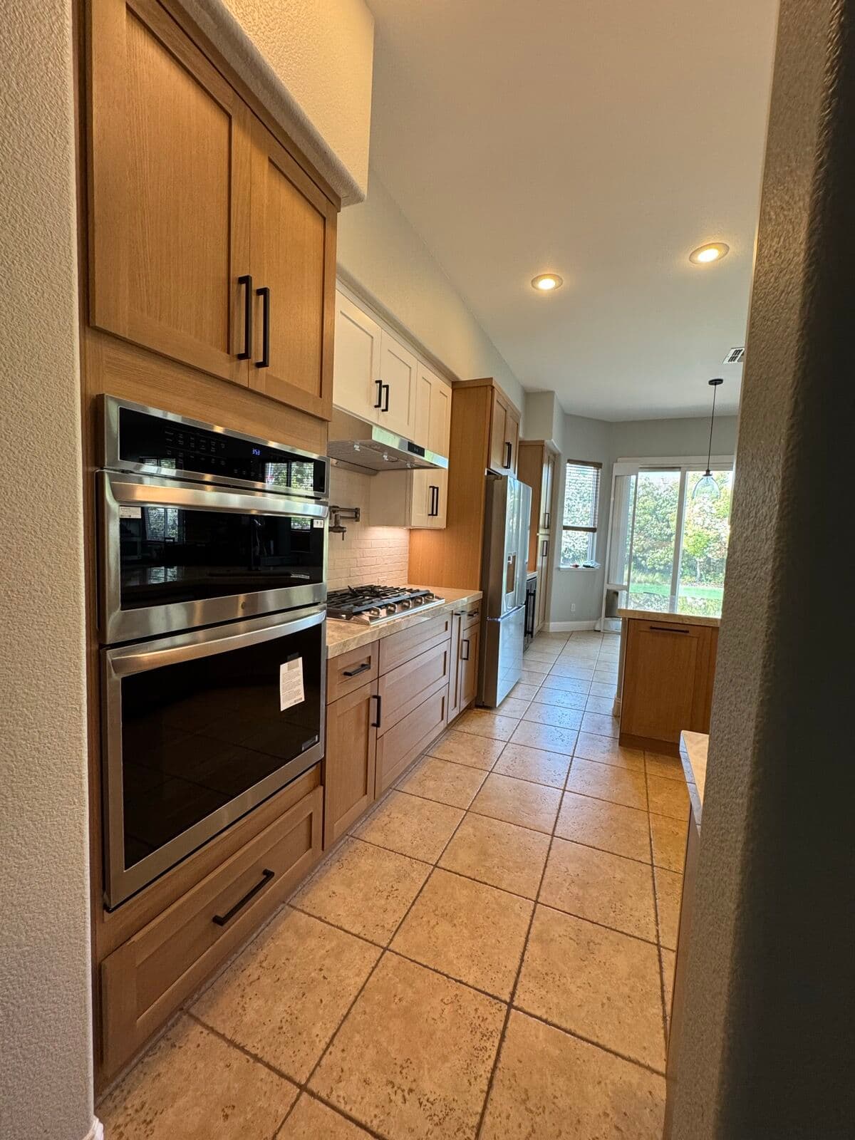 Kitchen with recessed ceiling lights, under-cabinet lighting and a pendant over the dining end