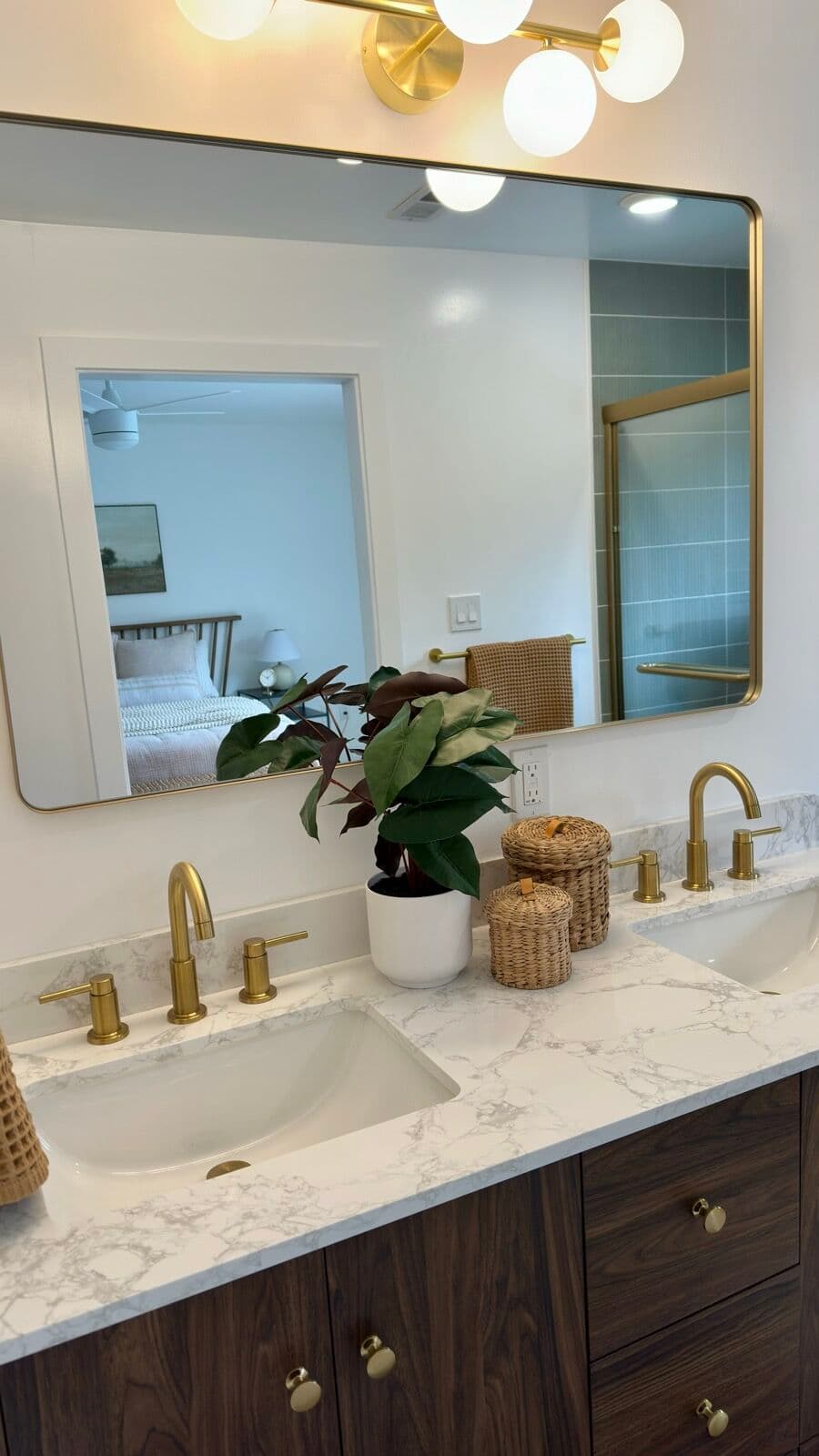 Double vanity with a marble-look stone top, undermount basins and brass faucets