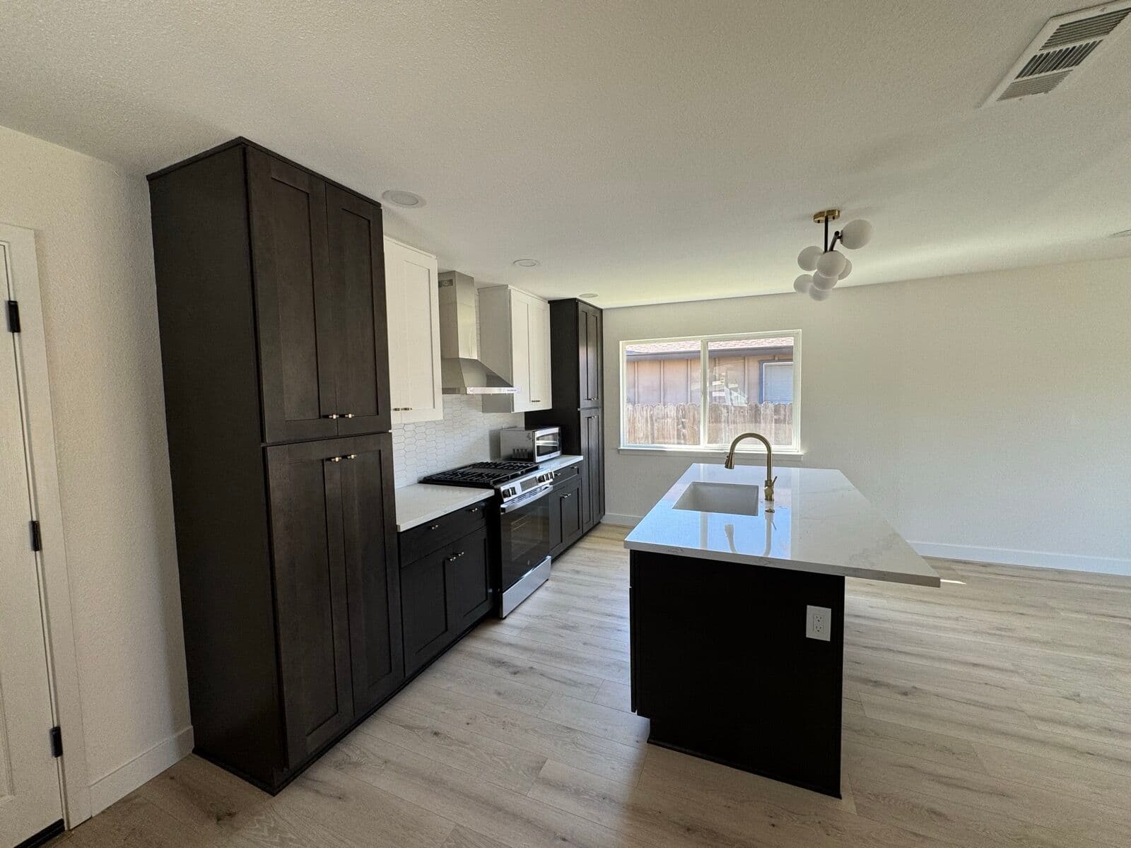 Charcoal-painted floor-to-ceiling pantry cabinets along a kitchen run