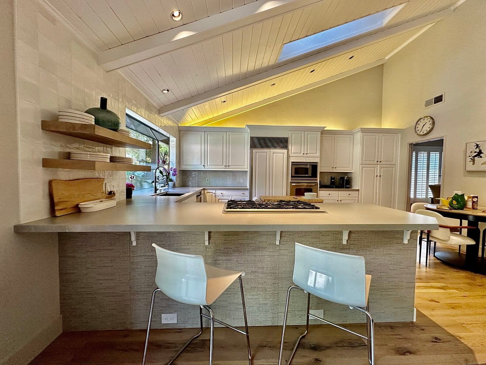 Kitchen with a gray quartz peninsula and white raised-panel cabinets