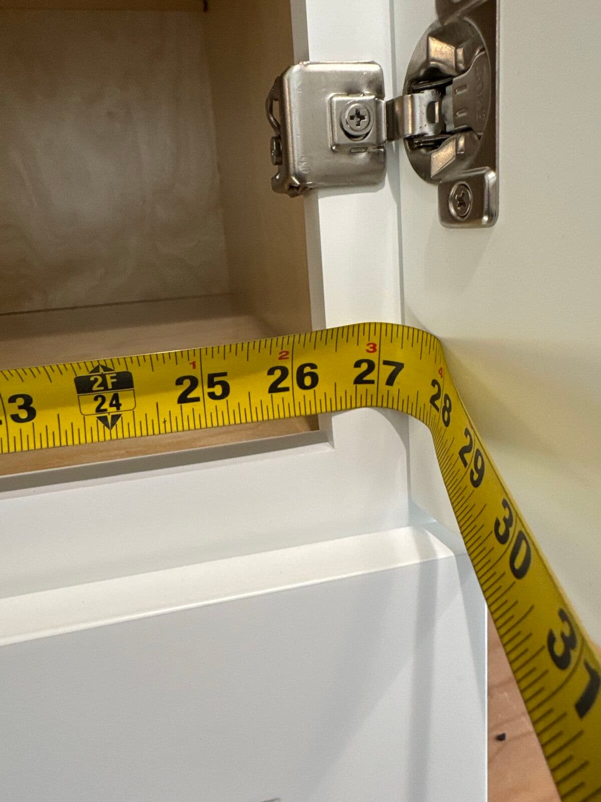 Tape measure across a farmhouse sink opening during templating